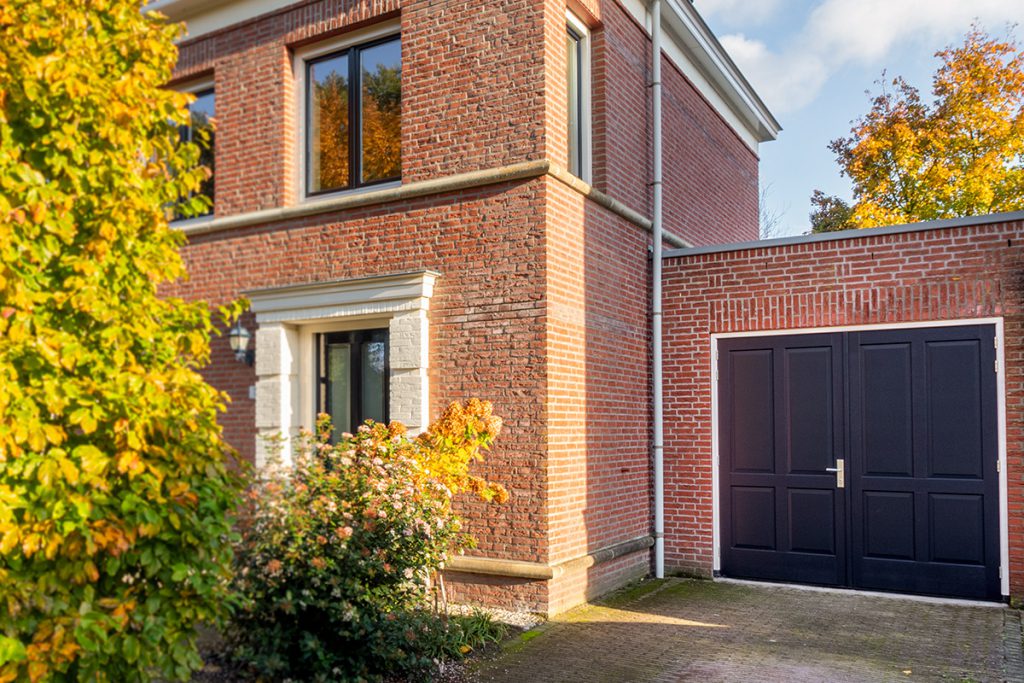 Houten garagedeur met sierlijsten