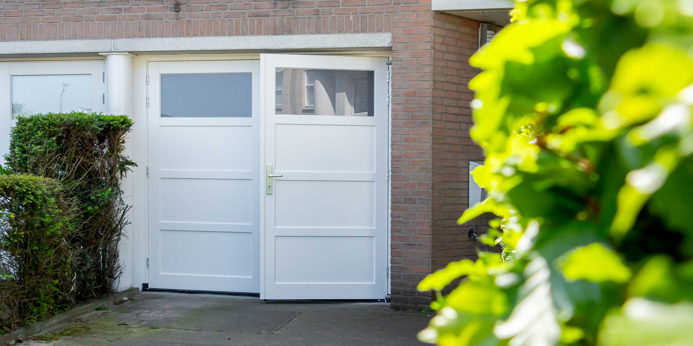 Witte houten openslaande garagedeuren