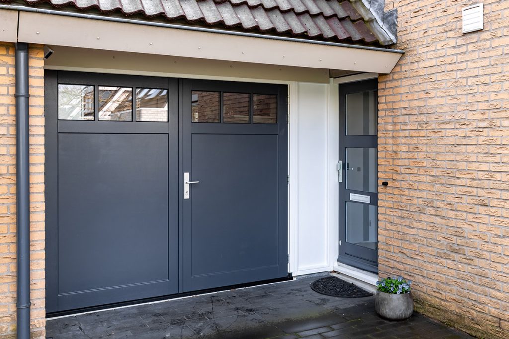 Raampjes bovenin houten openslaande garagedeuren
